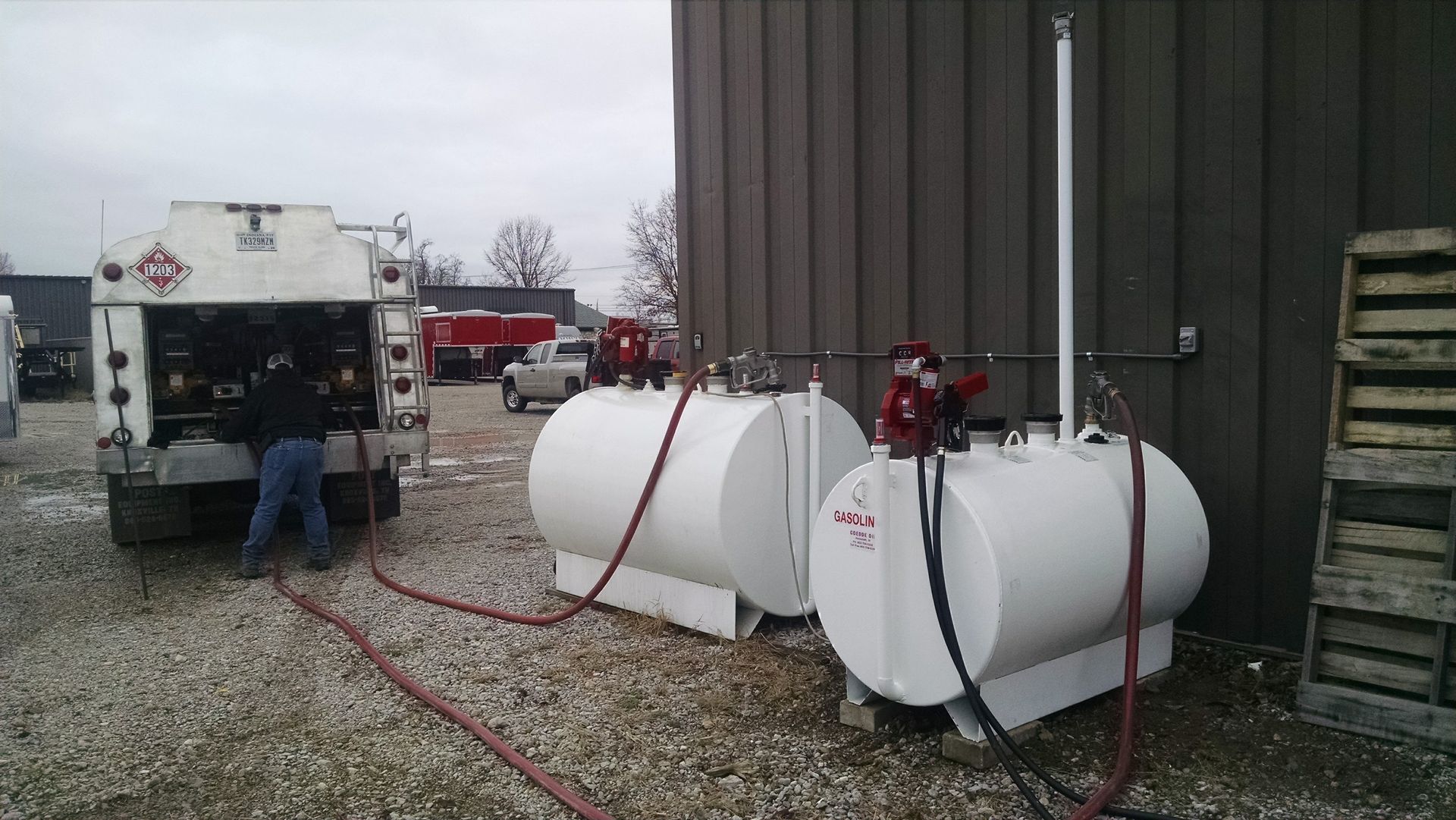 Two fuel tanks are connected to a truck in front of a building