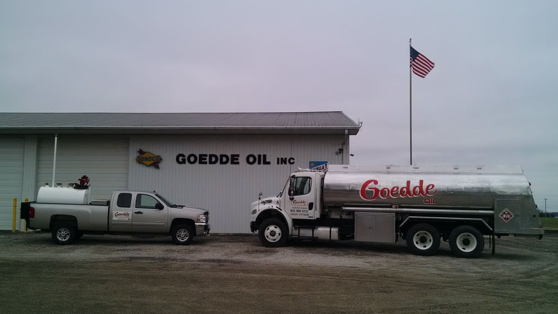 A tanker truck is driving down a road with mountains in the background.