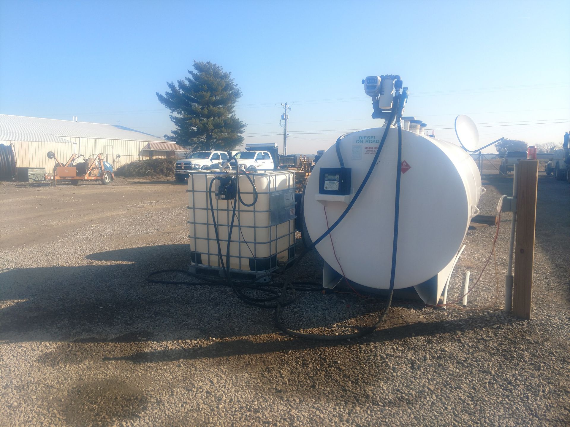 Two fuel tanks are connected to a truck in front of a building