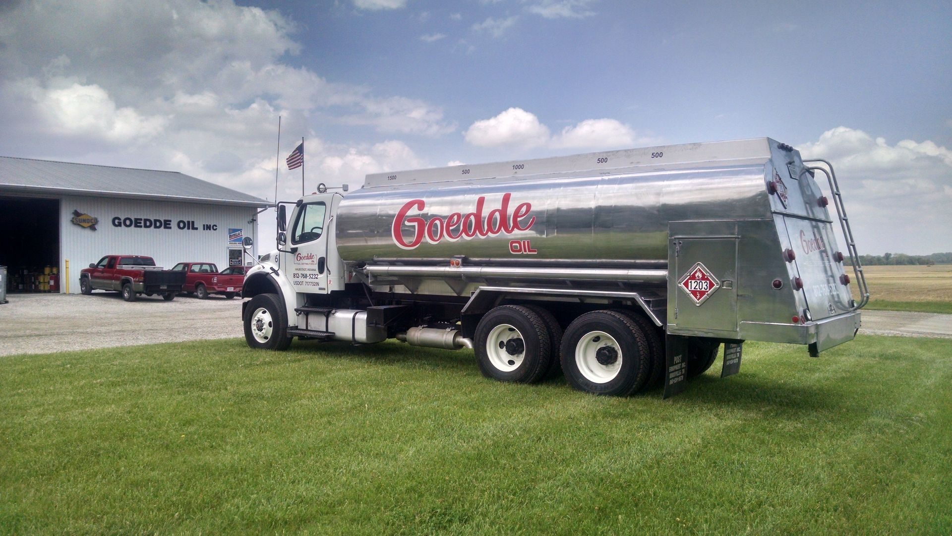 Two tanker trucks are parked next to each other in a parking lot.