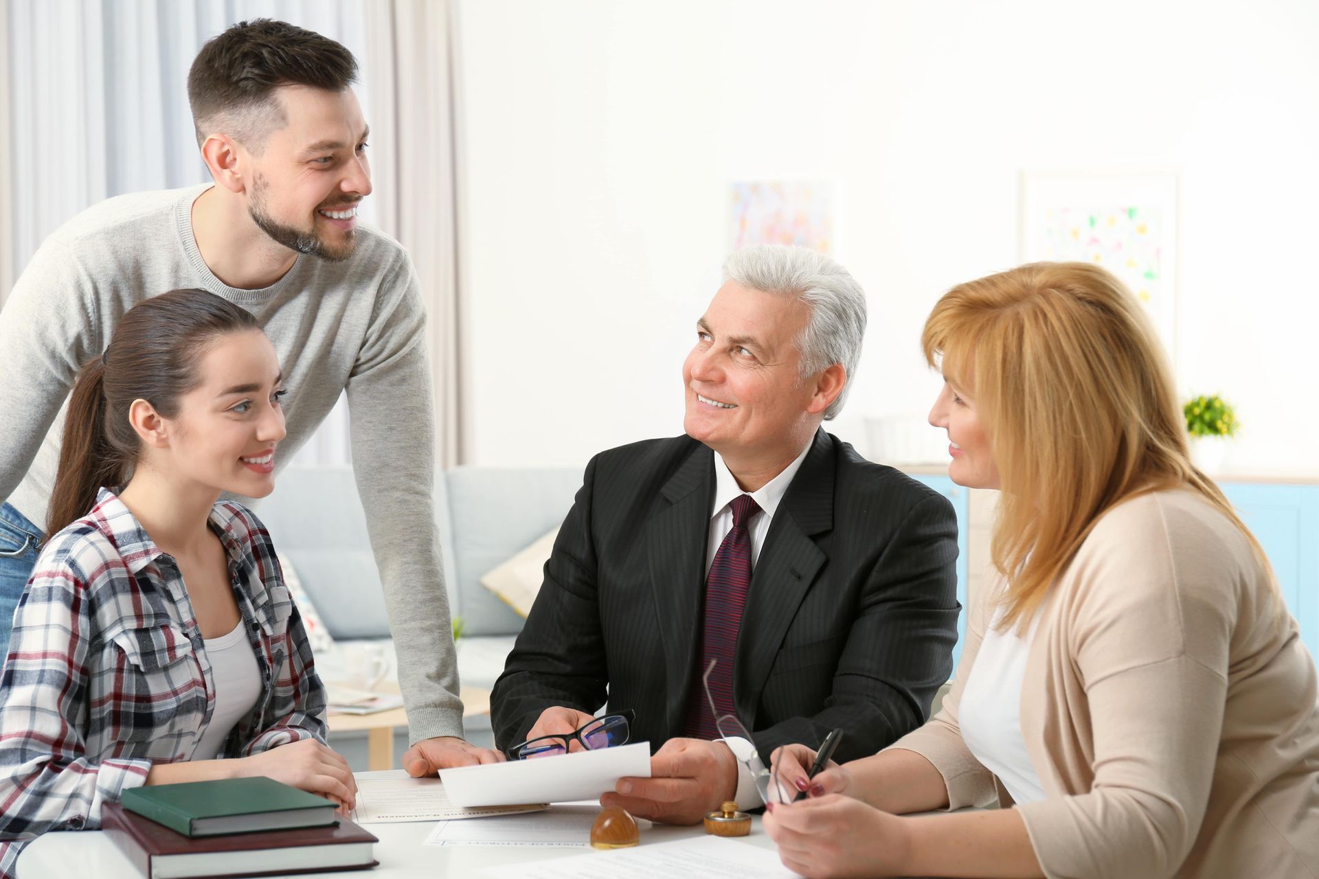Family meeting with a lawyer at a table; smiling and discussing documents.
