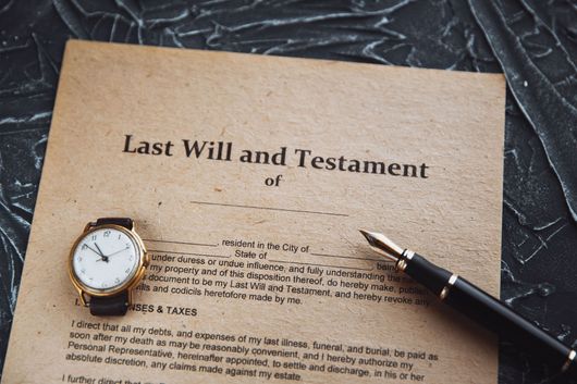 Last Will and Testament document with a pen and watch on a textured surface.