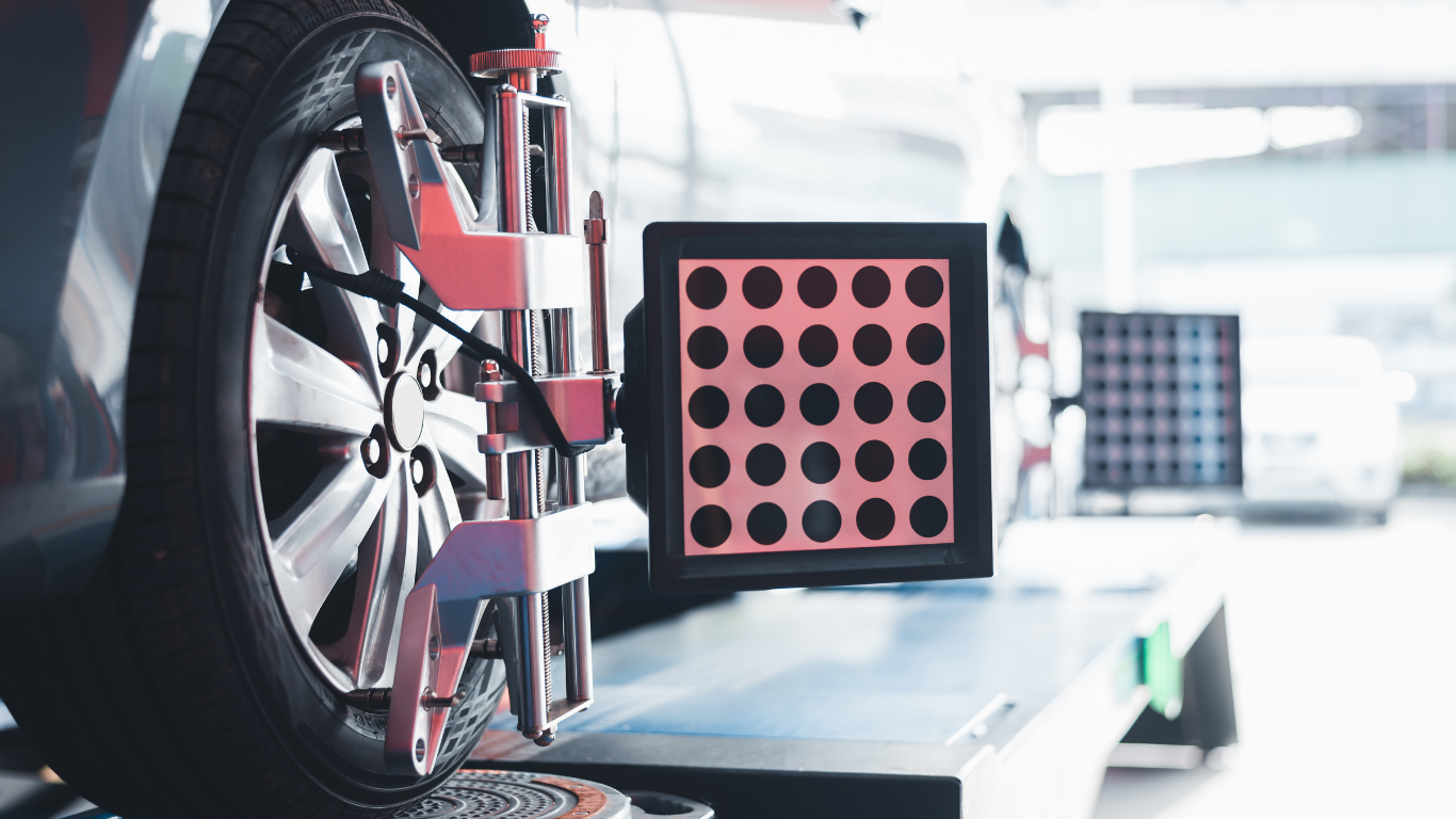 Car wheel being aligned in a repair shop, with alignment equipment attached.