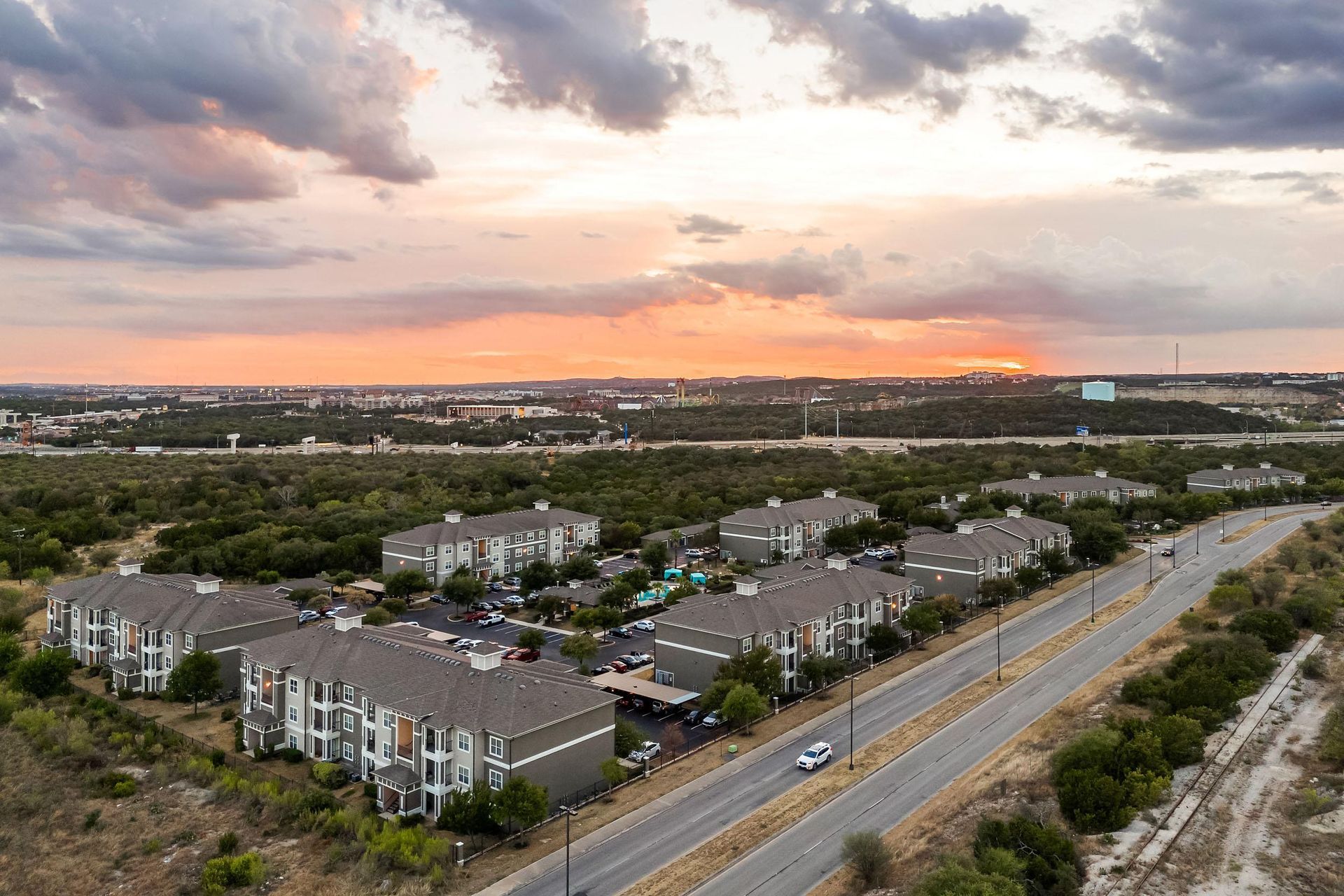 an aerial view of a row of houses with a sunset in the background