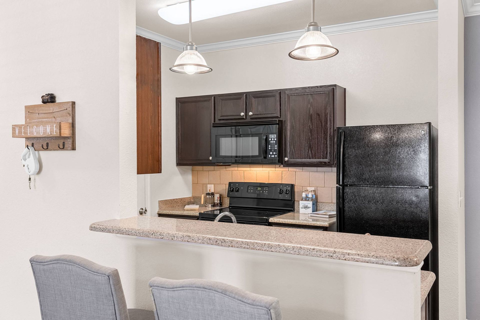a kitchen with a breakfast bar and black appliances