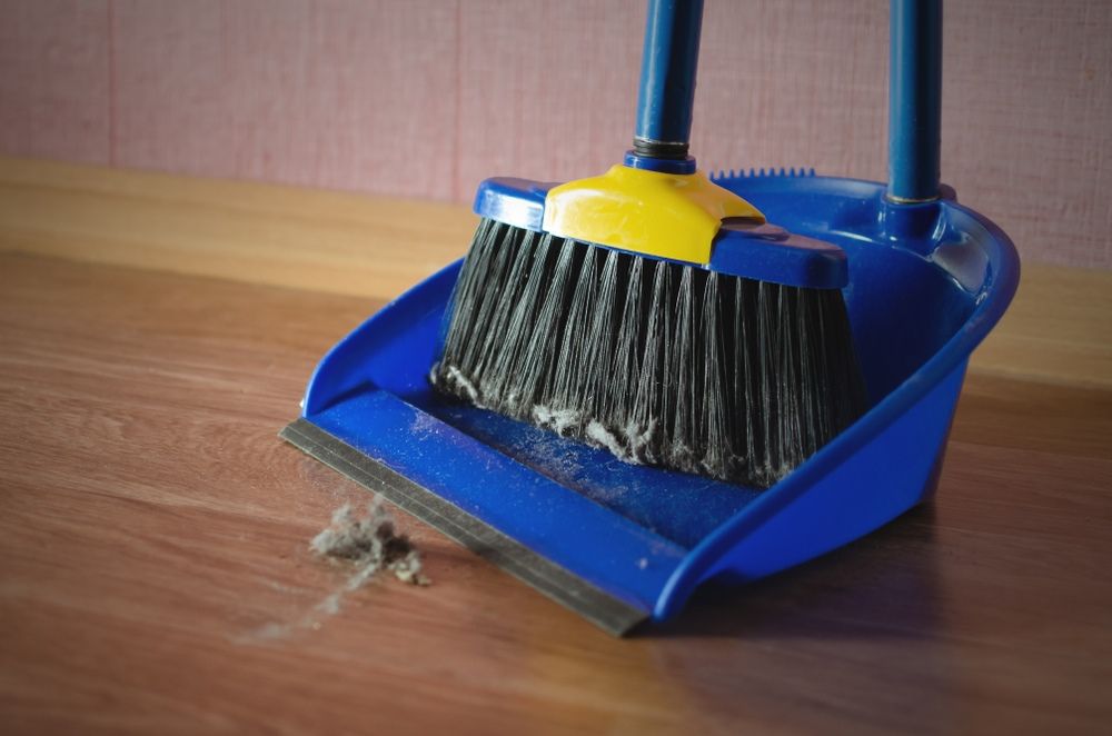 A Broom And Dustpan Are Sitting On A Wooden Table — Sadie's Cleaning Services in Koongal, QLD