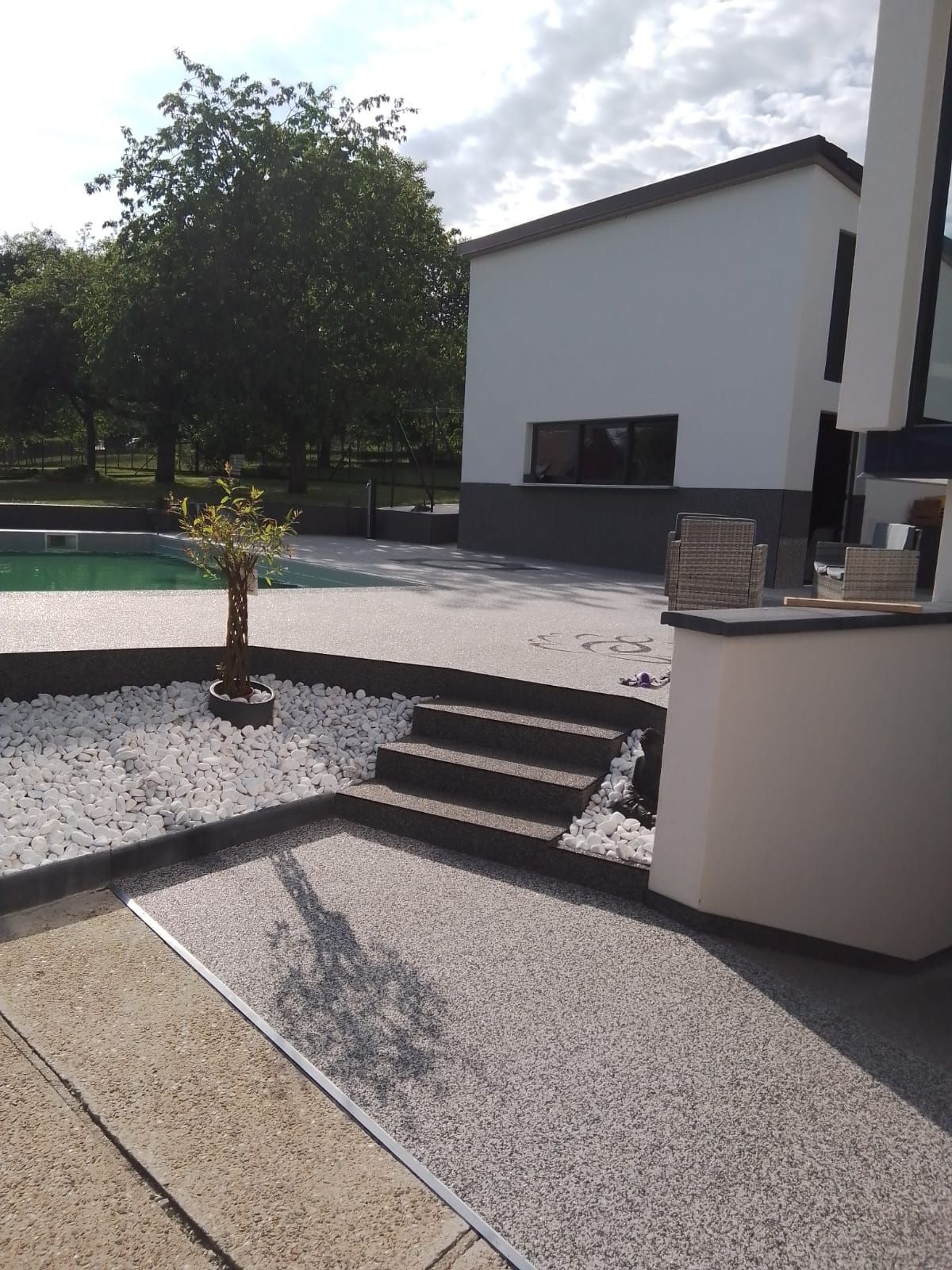 Une maison blanche avec une piscine dans l'arrière-cour.