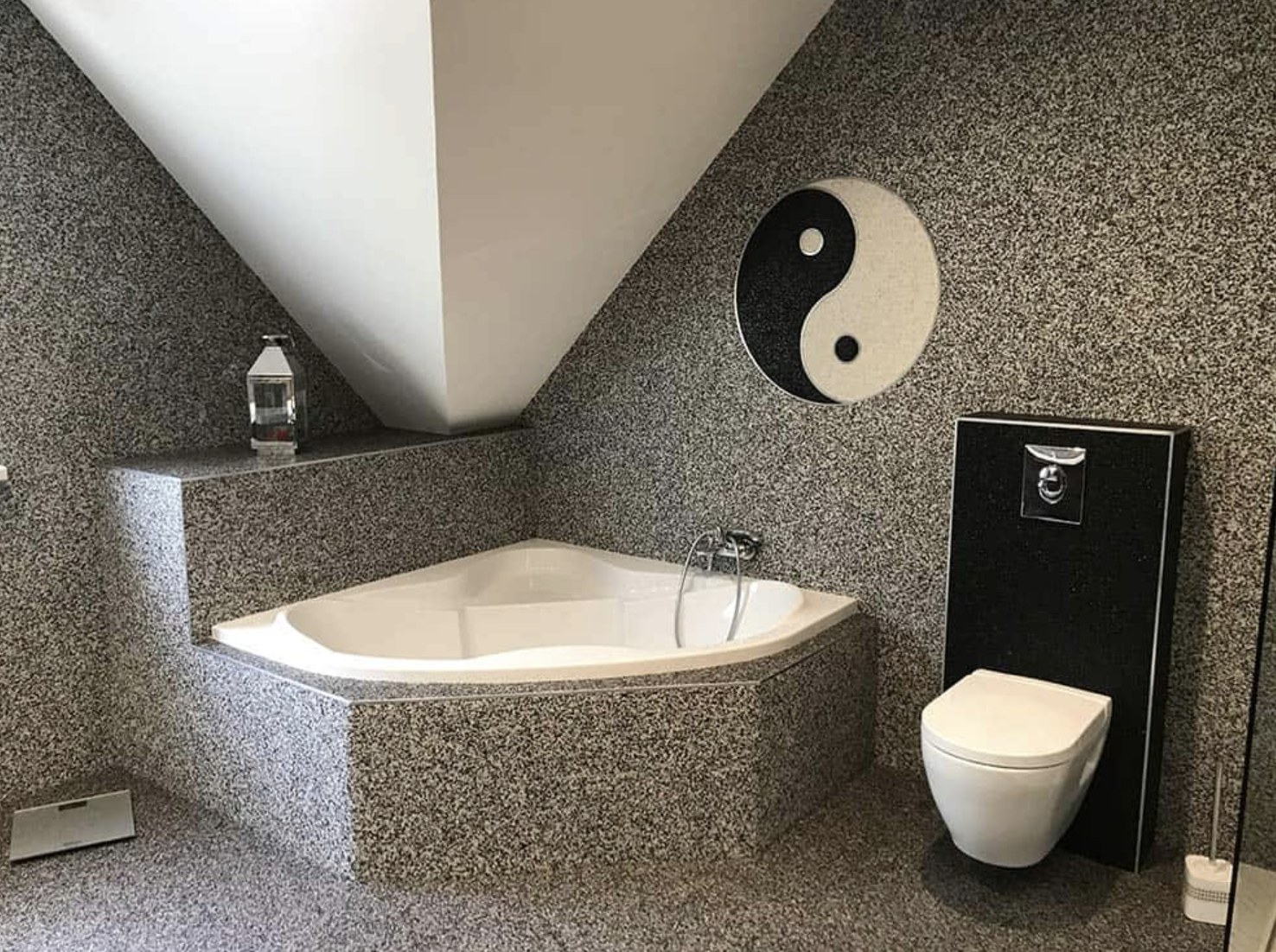 Une salle de bain avec baignoire, toilettes et symbole yin yang sur le mur.