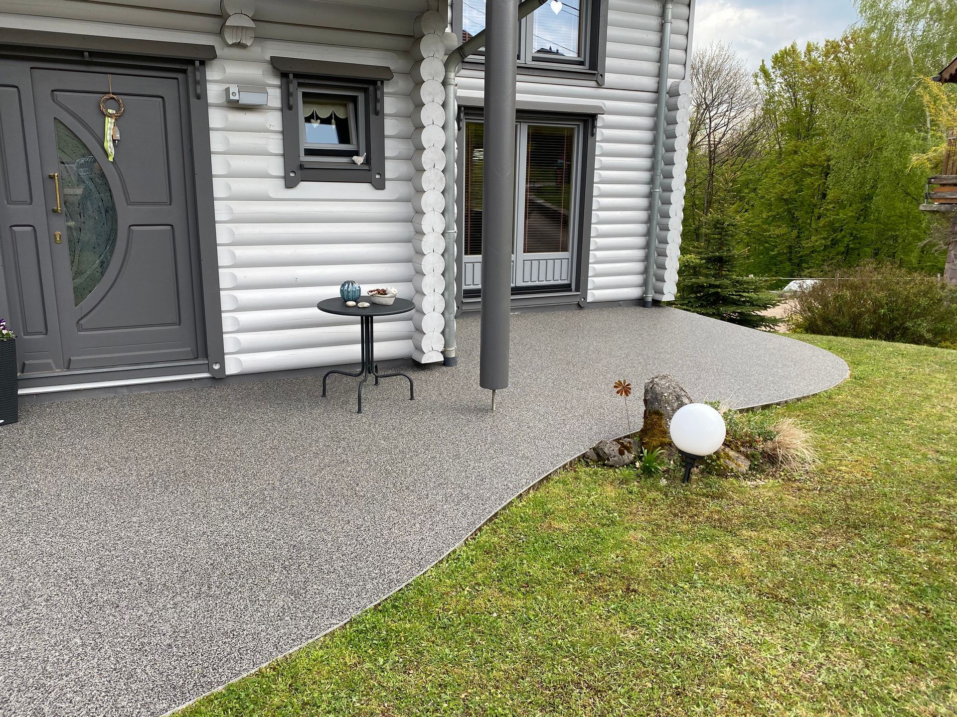 Une maison avec un porche et une table devant.