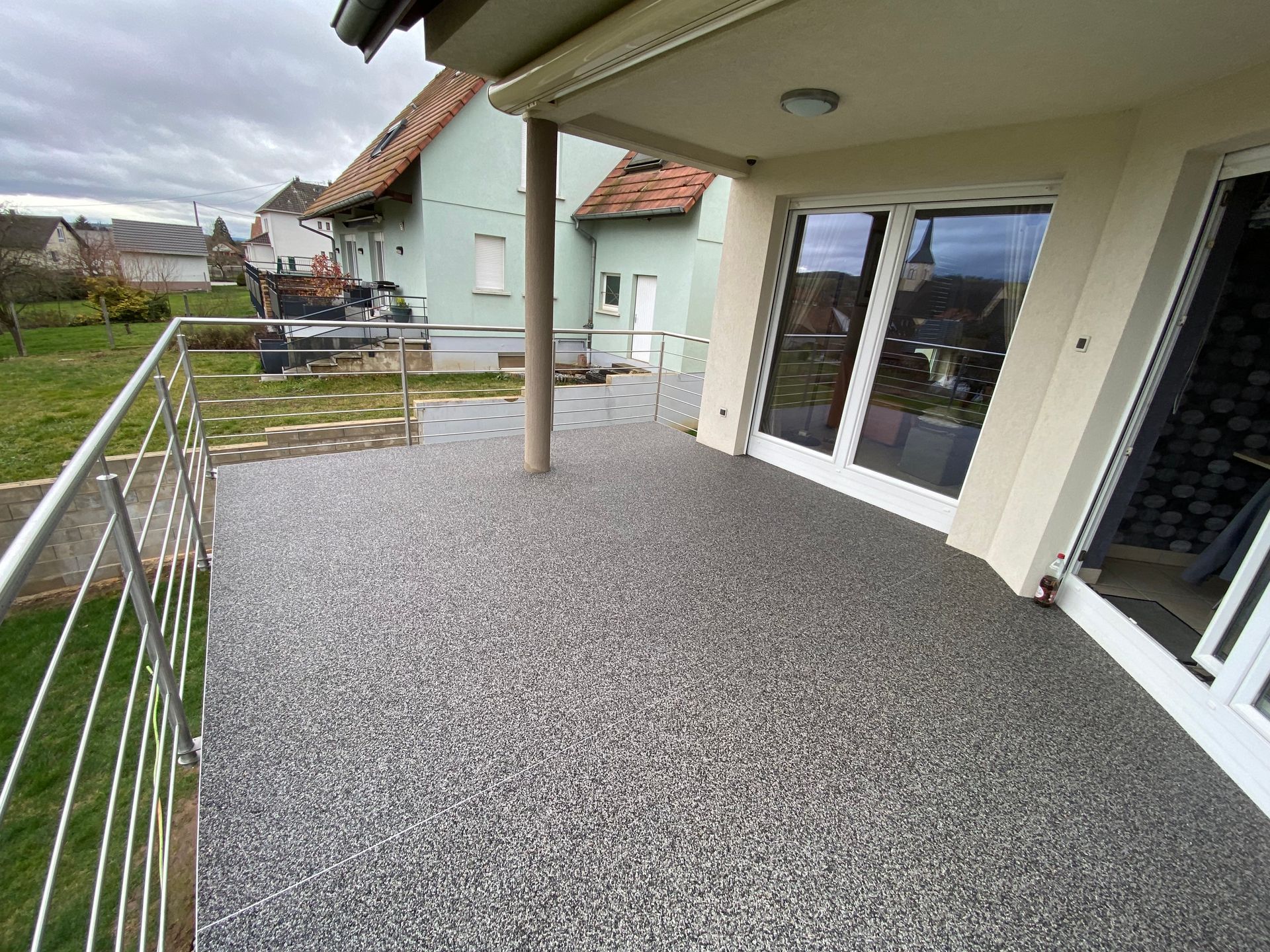 Un balcon avec une balustrade en métal et des portes coulissantes en verre