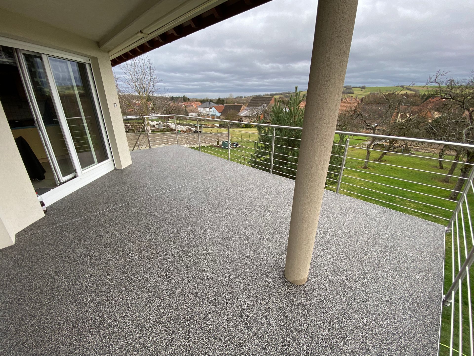 Un balcon avec vue sur un champ verdoyant.