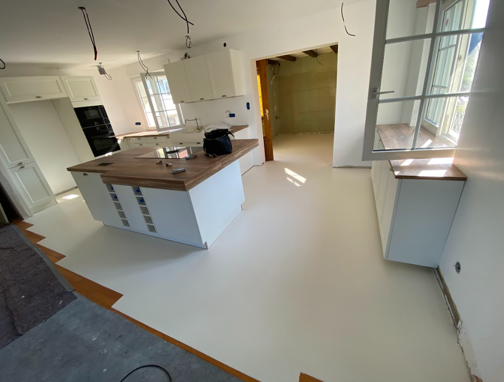 Une cuisine avec des armoires blanches et un comptoir en bois.