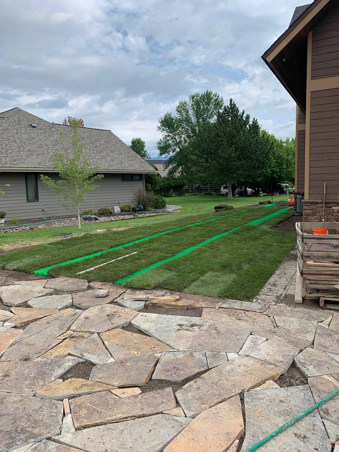 A house with a lawn and a patio in front of it.