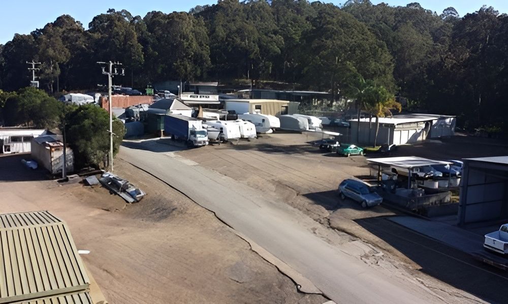 A White Garage is Sitting in the Middle of a Dirt Field Surrounded by Trees — Teralba Business & Storage Park in Teralba, NSW