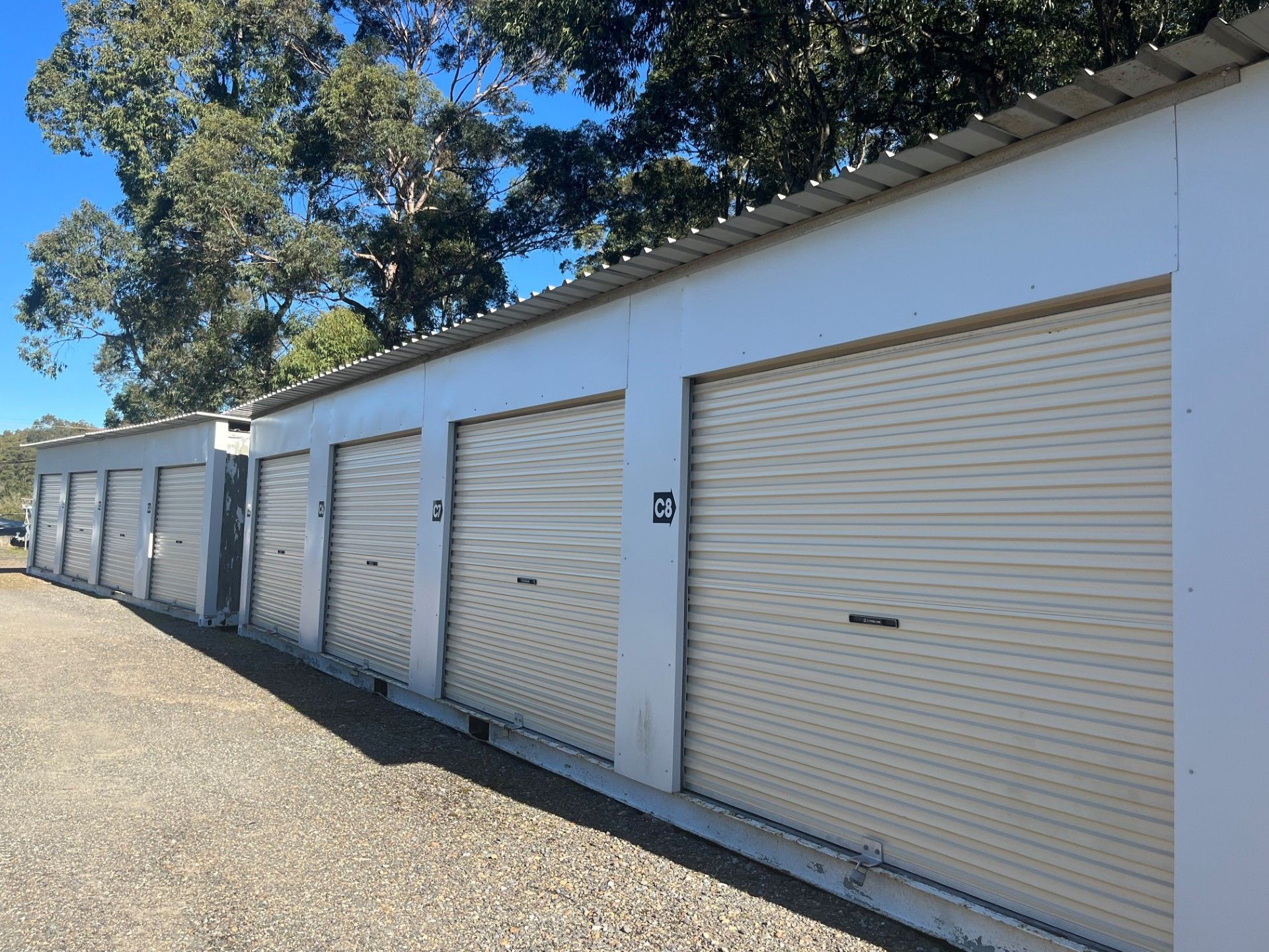A Row of Storage Units With Yellow Doors and a Motorcycle in One of Them — Teralba Business & Storage Park in Teralba, NSW