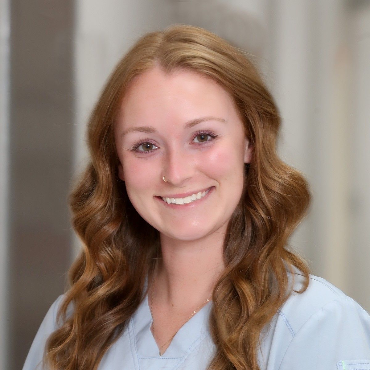 A woman with long red hair is smiling for the camera.