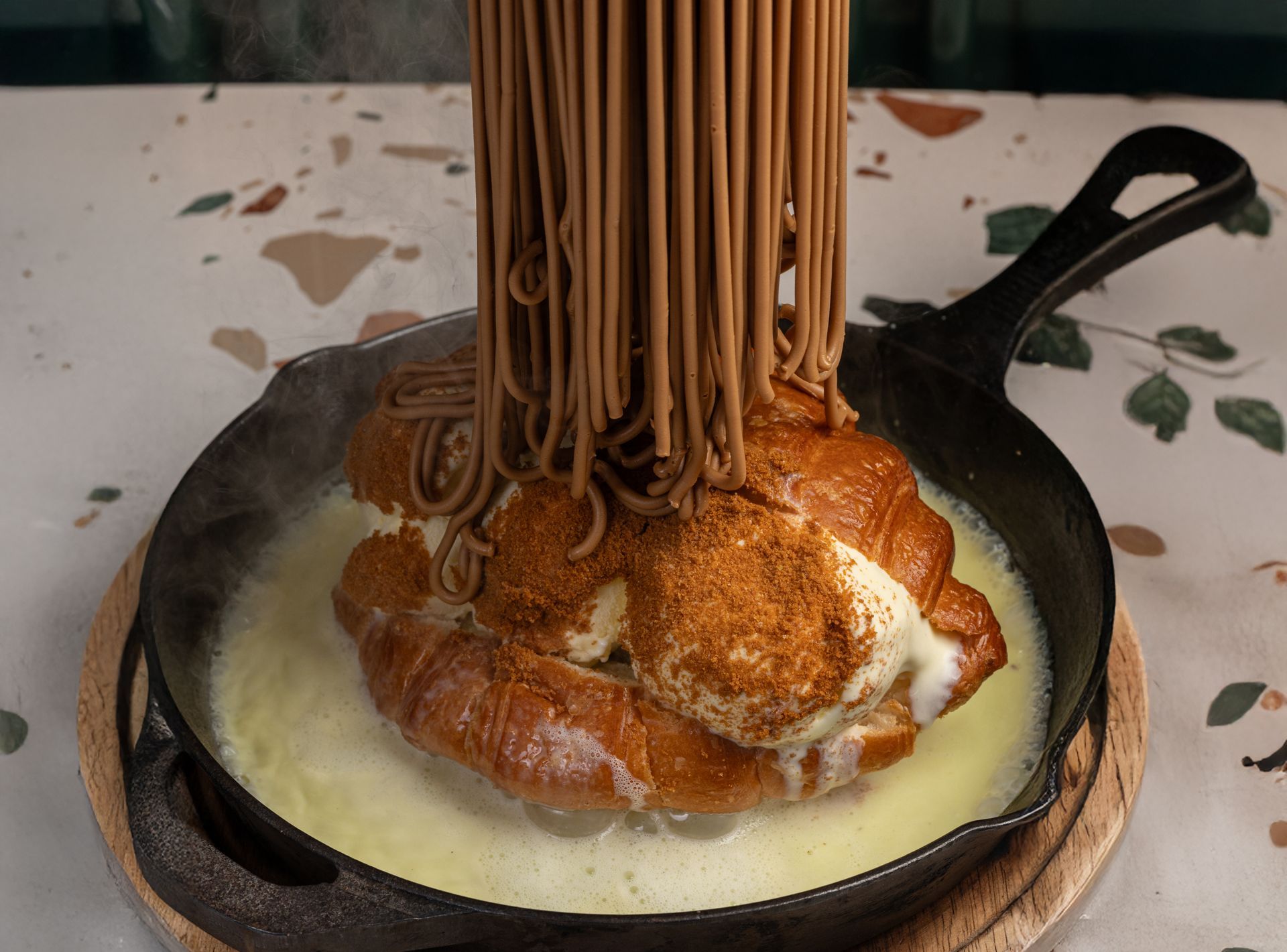 A close up of a dessert in a gold bowl on a table.
