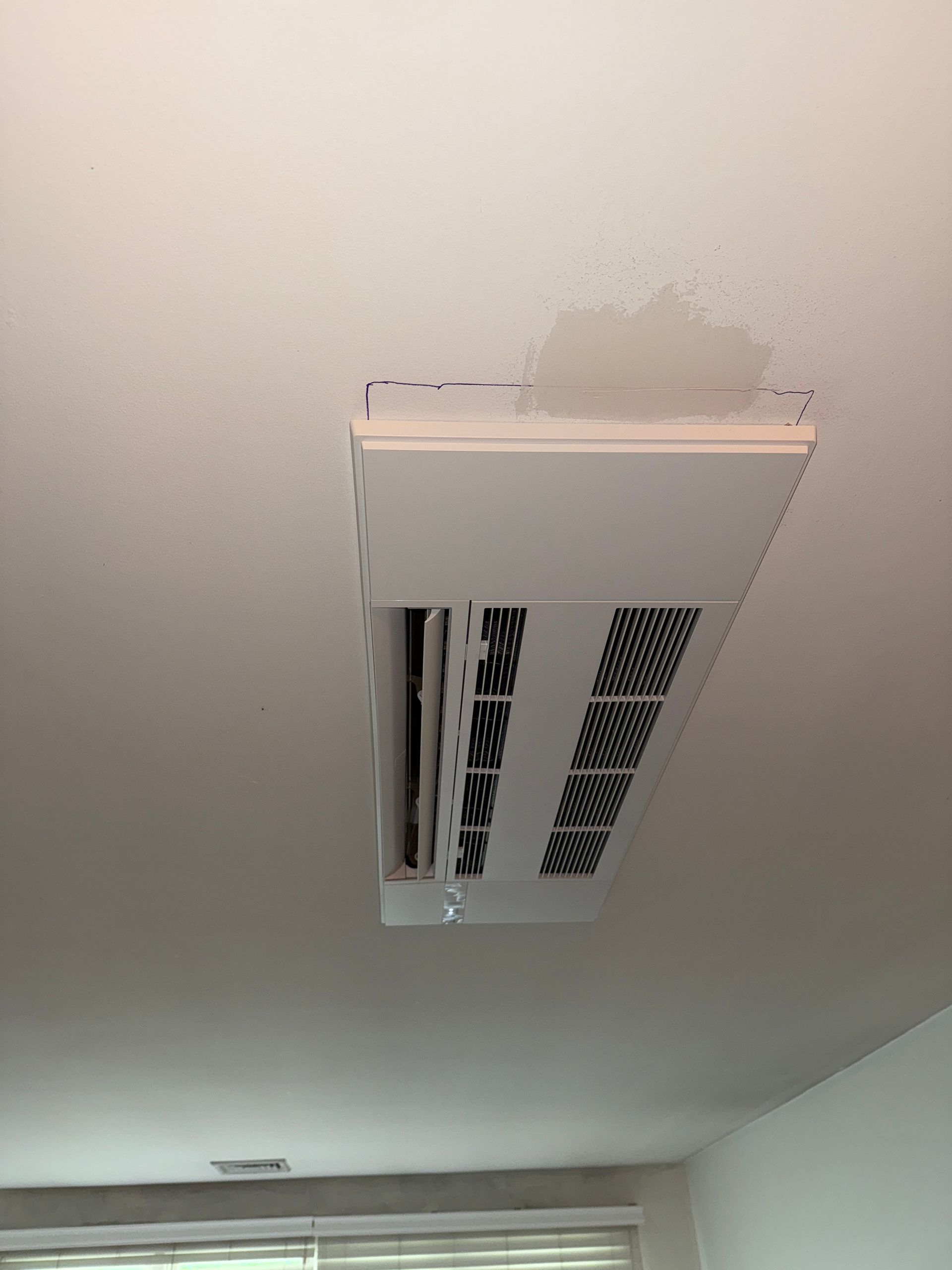 White ceiling-mounted air vent, with water damage spot.