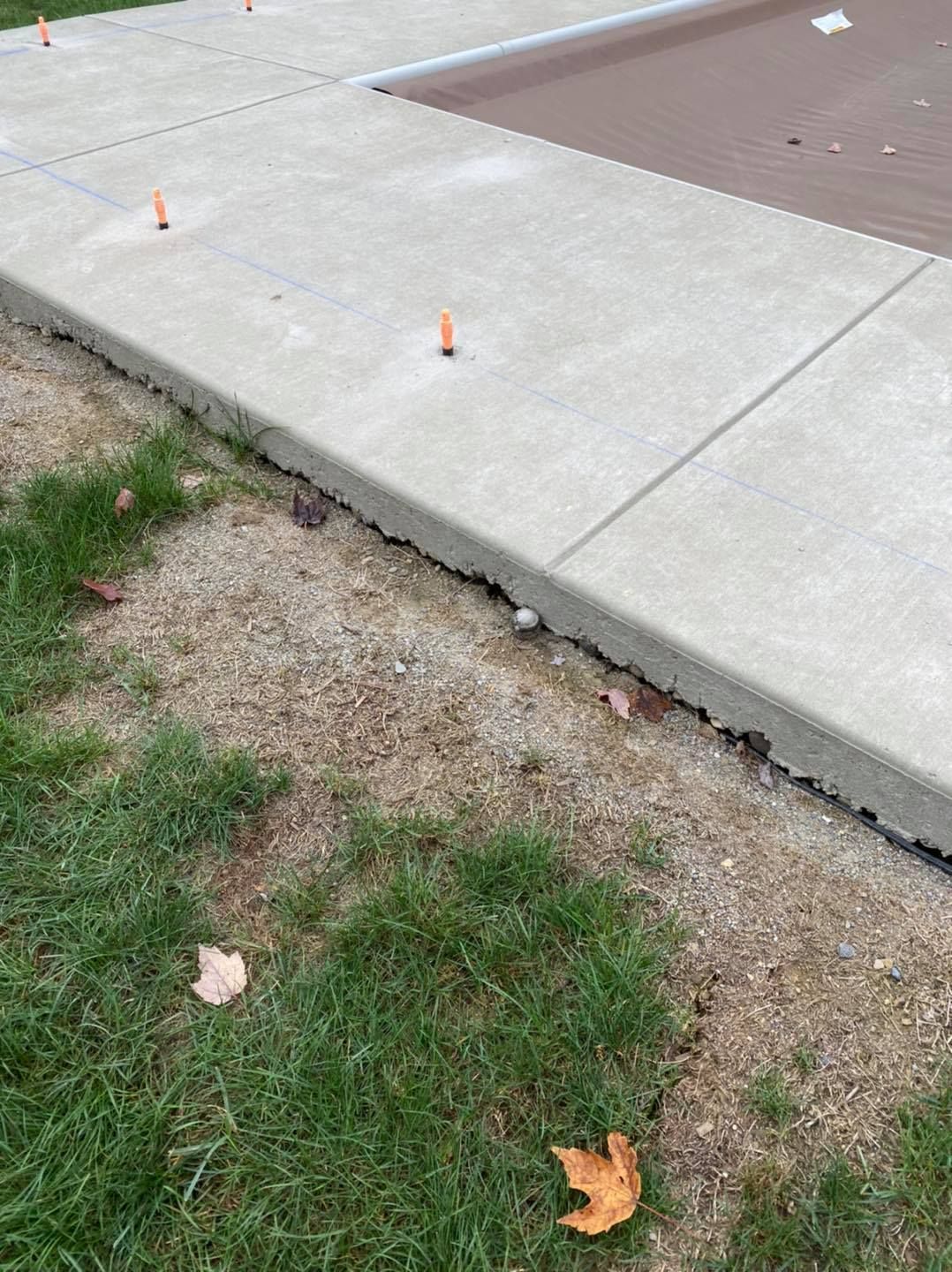Concrete sidewalk with edge cracking and separating from gravel and grass.