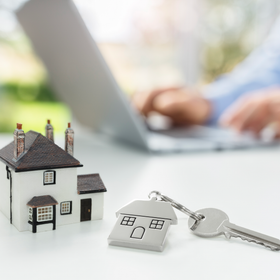 A small house figuring on a table indicates real estate worker.