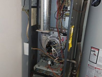 The inside of a heating system with a water heater next to it.
