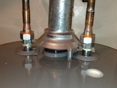 A close up of a water heater with nuts and bolts on it.