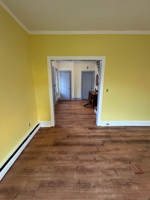 Yellow-painted room with brown flooring; doorways lead to other rooms with blue doors. White trim.