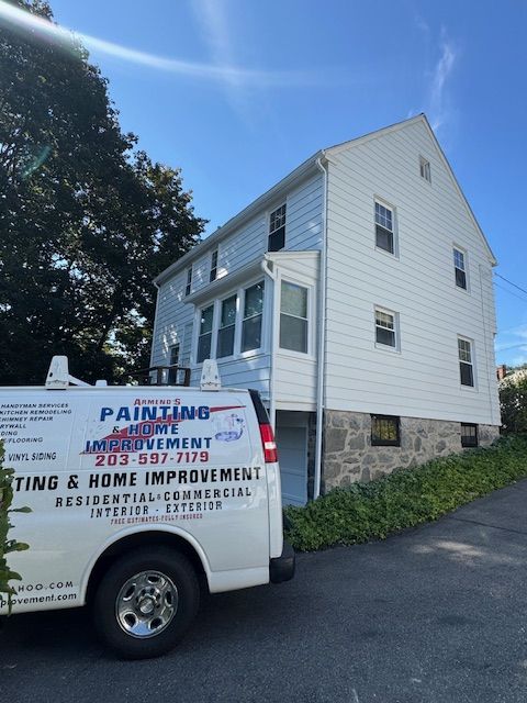 White house with a parked painting & home improvement van in front.