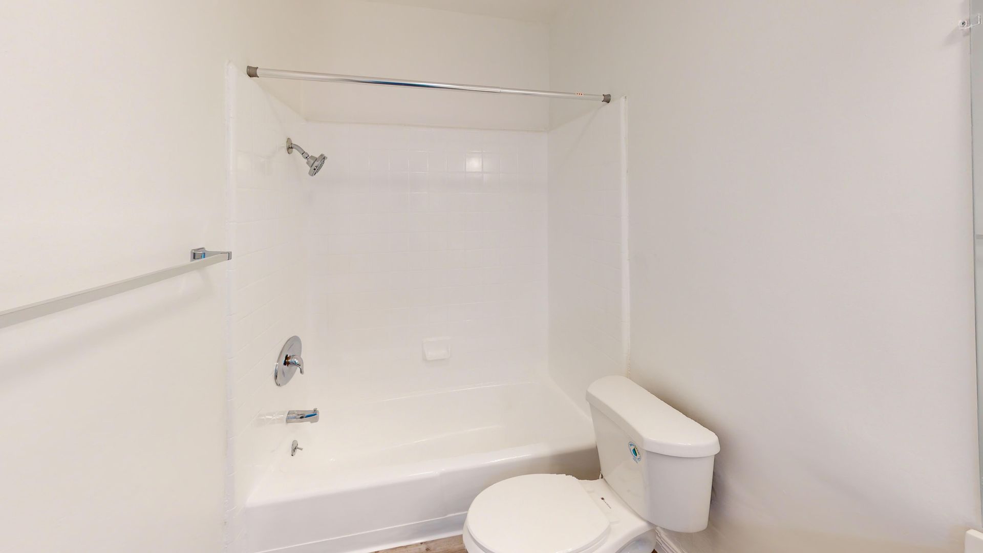 White bathroom with shower/tub combo and toilet.