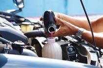 Mechanics pouring coolant — Vehicle Repairs in Grafton, NSW