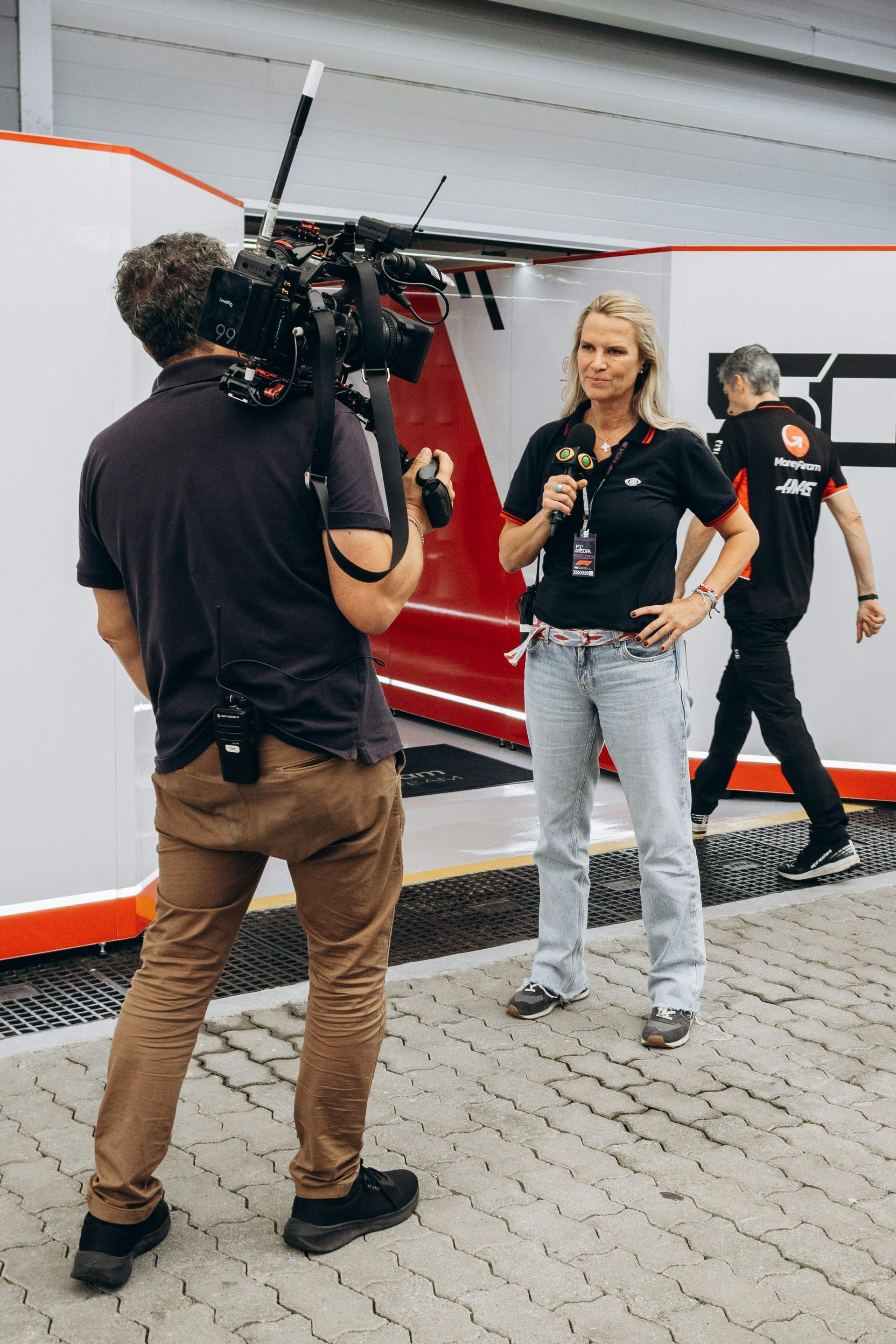 A man is taking a picture of a woman talking into a microphone.