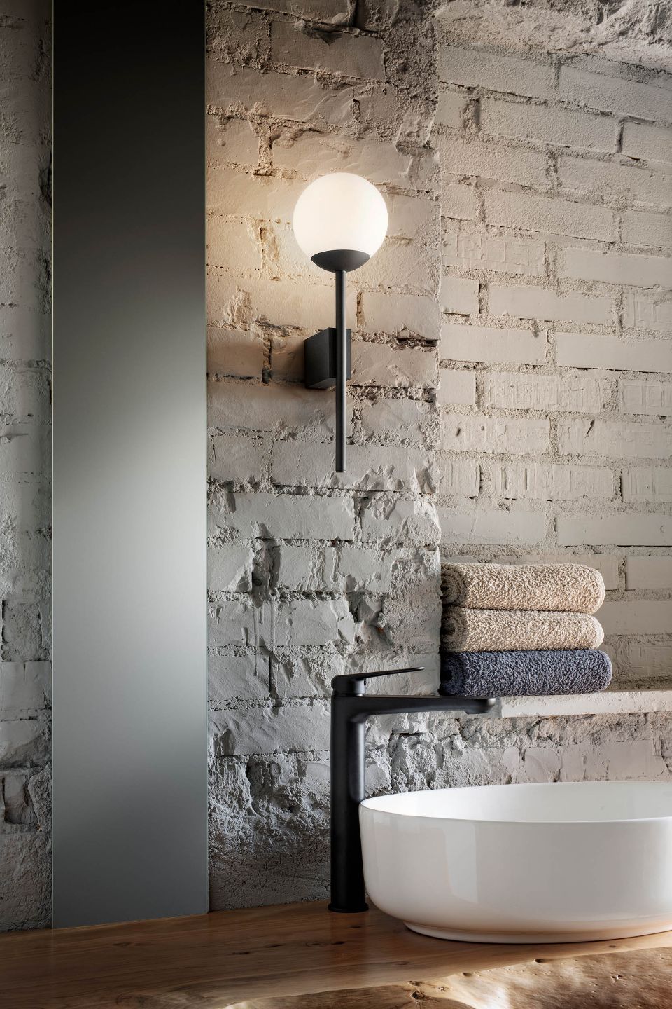 Lampada a parete su muro grezzo