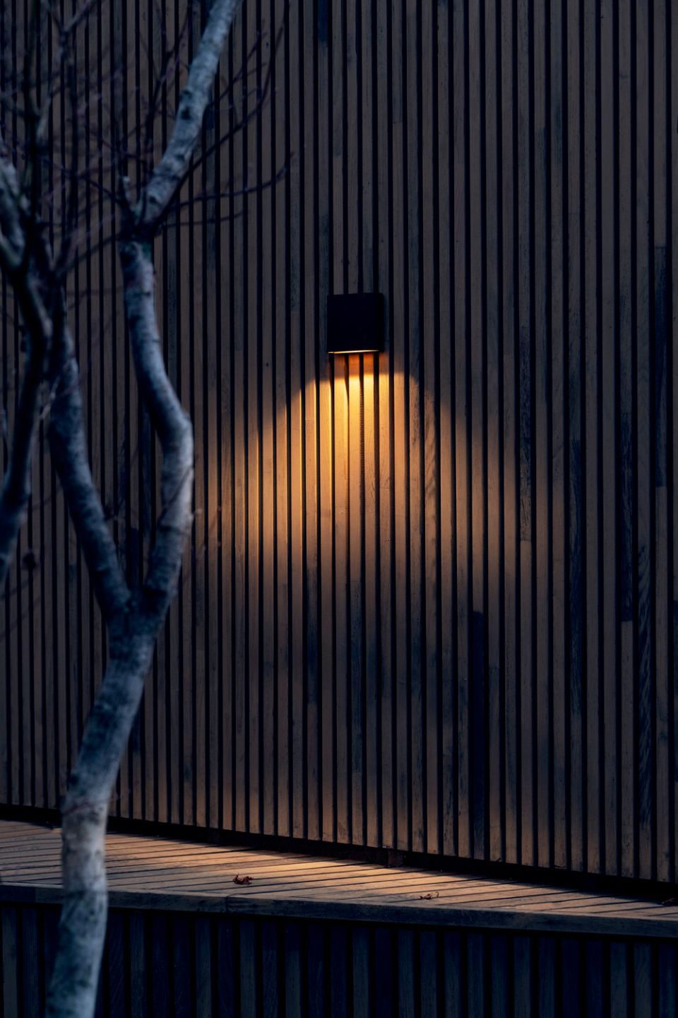 Lampada per esterni su muro in legno