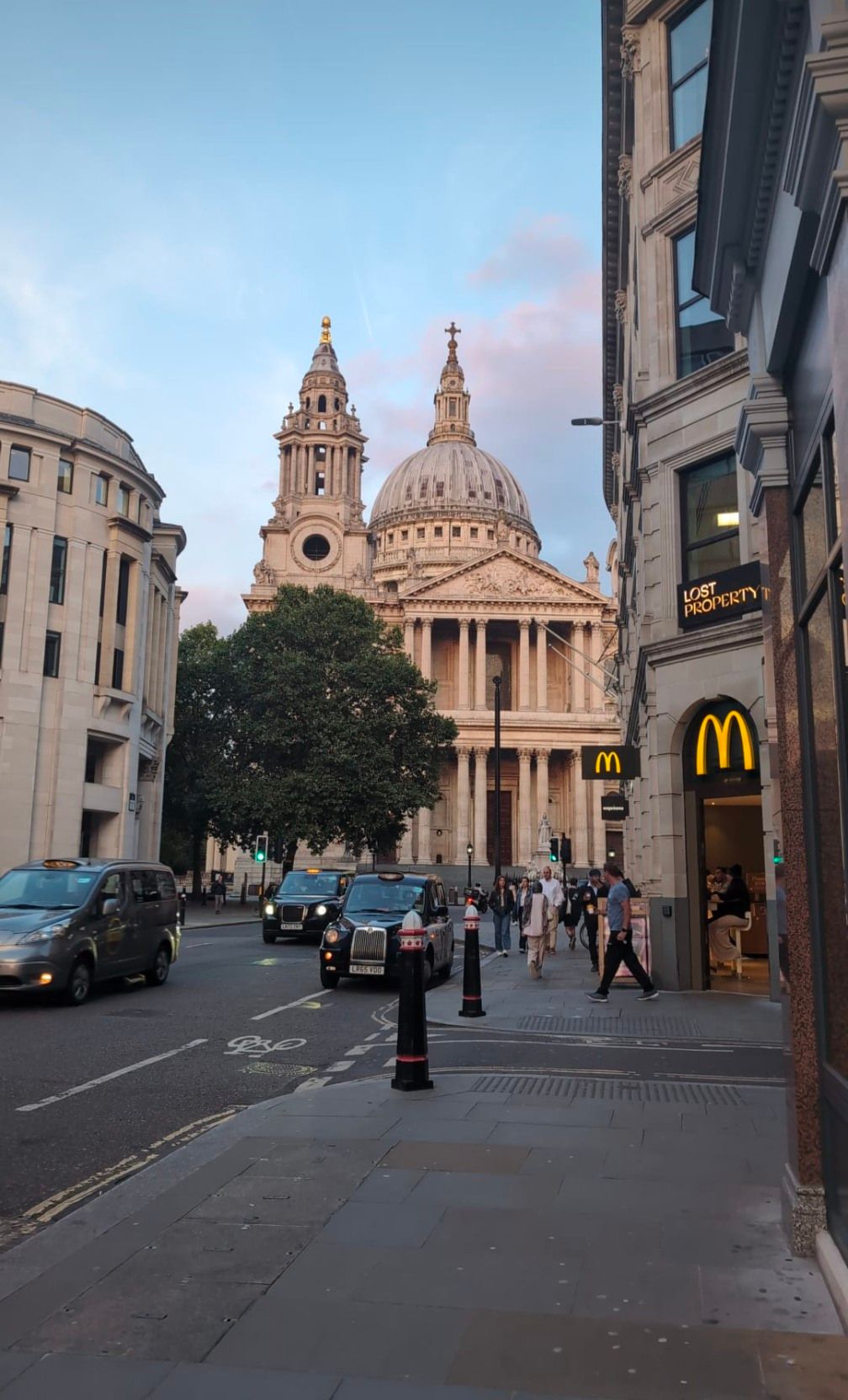 A street with a mcdonald 's and a church in the background