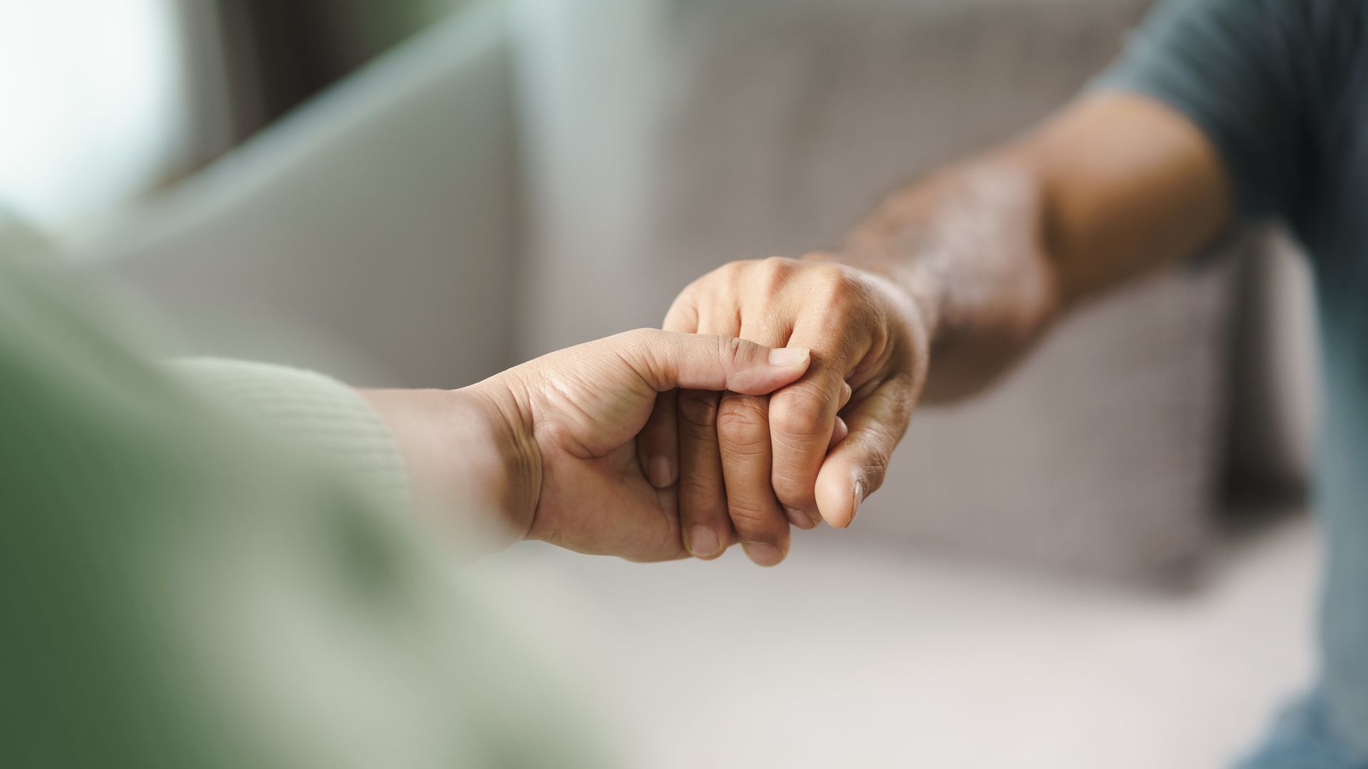 A close up of a person holding another person 's hand.