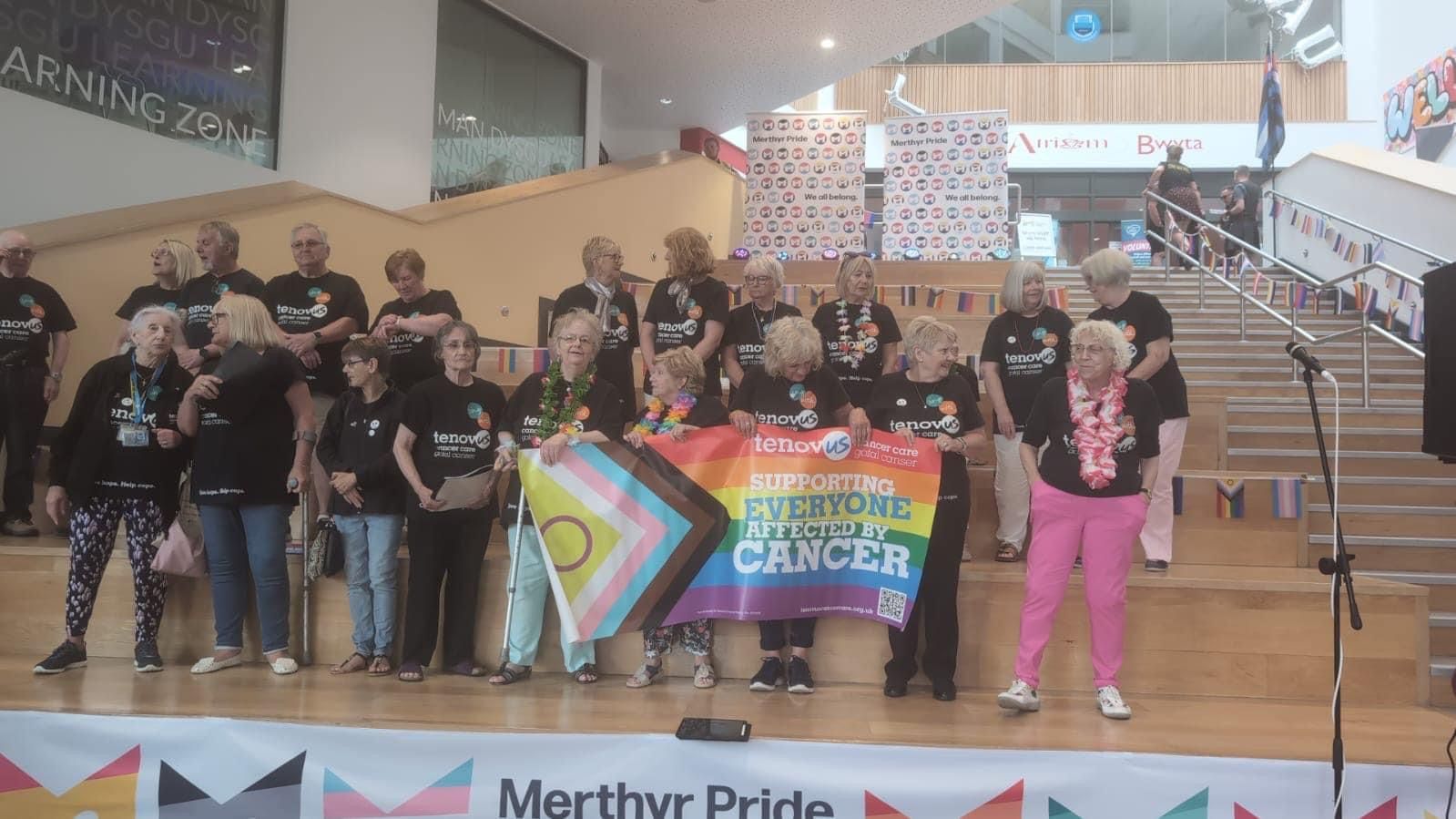 A group of people standing on a stage holding a banner that says everyone matters cancer