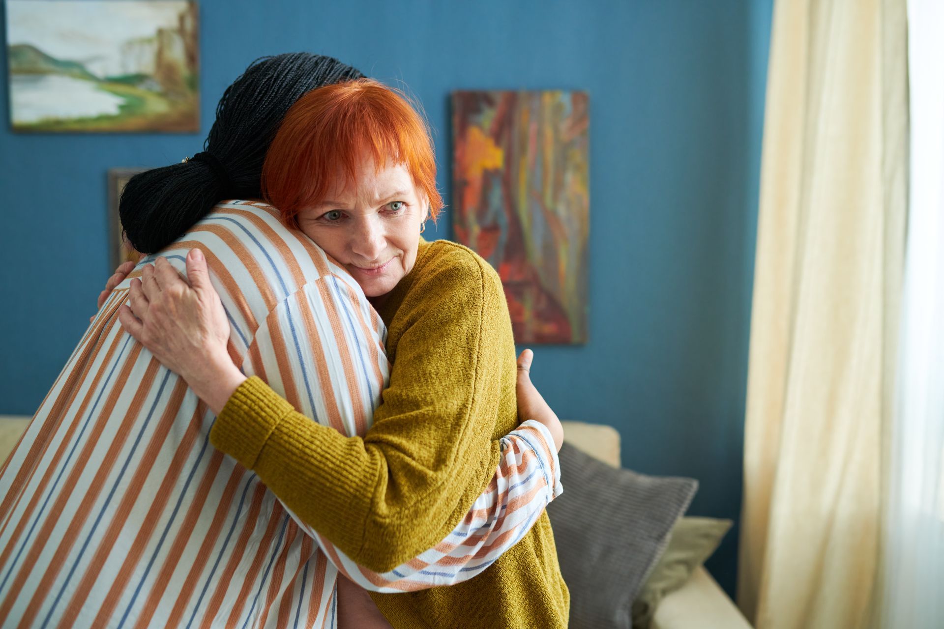 A woman is hugging a man in a living room.