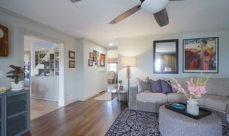 Living room with light blue walls, hardwood floors, and a sectional sofa.