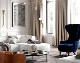 Living room with white sofa, blue chair, curtains, and artwork.