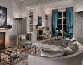 Elegant living room with grey seating, teal curtains, and art.