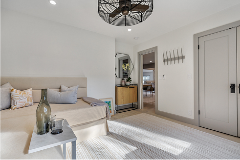 Bedroom with a daybed, side table, and a doorway to another room.