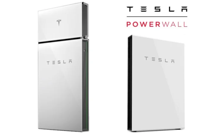 Two large batteries connected with black cables, inside a white cabinet, with a danger label on one.