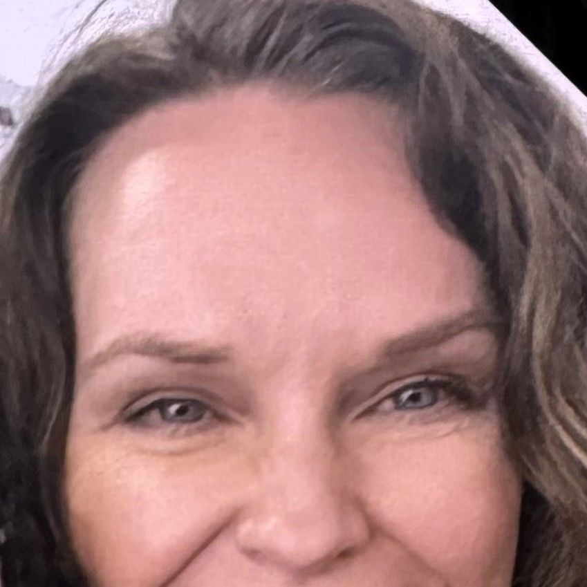 A close up of a woman 's face with a smile on her face.