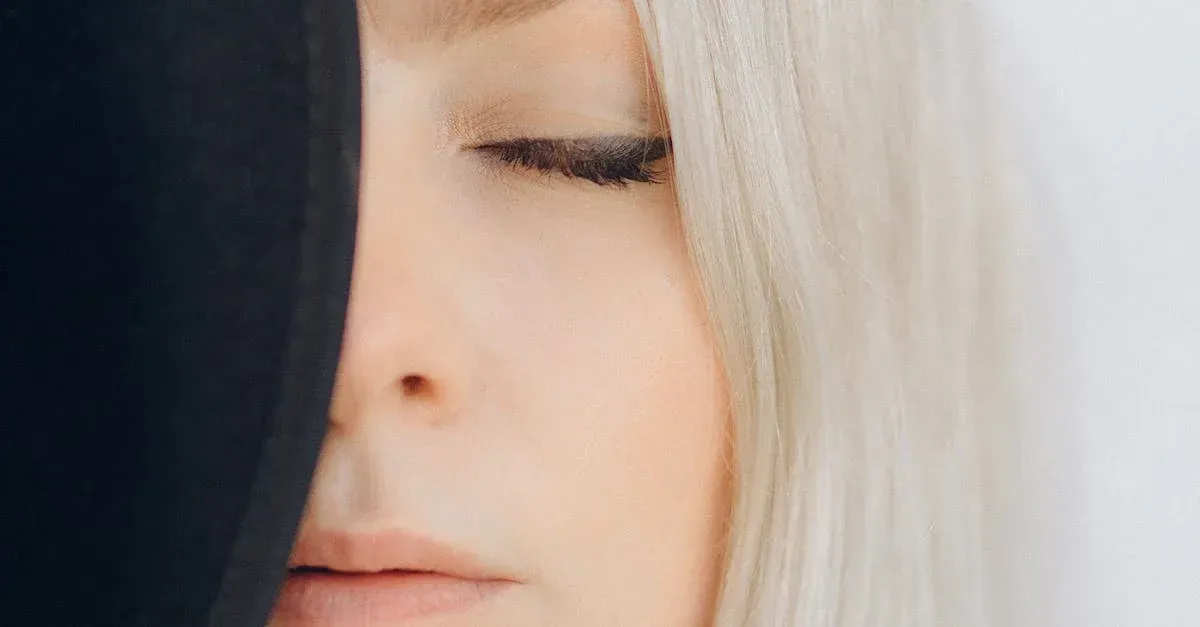 a close up of a woman 's face with her eyes closed .