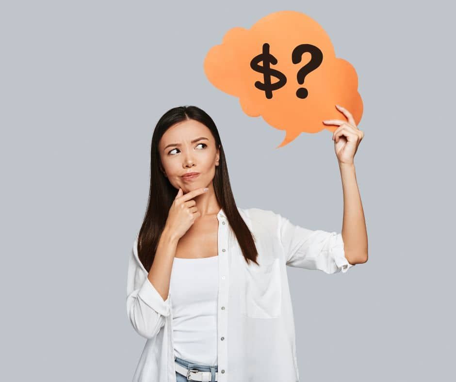 A woman is holding a speech bubble with a dollar sign on it.