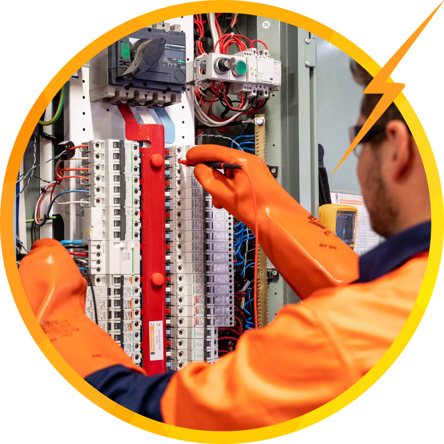 Electrician in orange gloves testing electrical panel with wires.