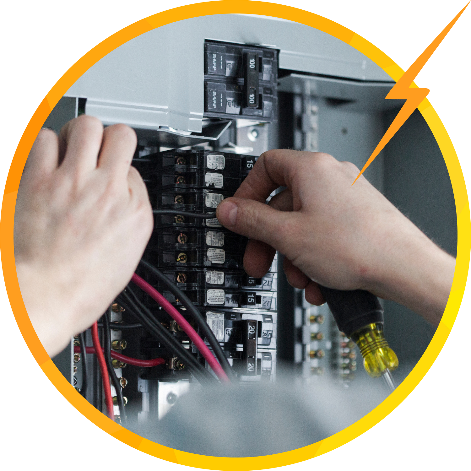 Electrician working on electrical panel, installing wires with a screwdriver.