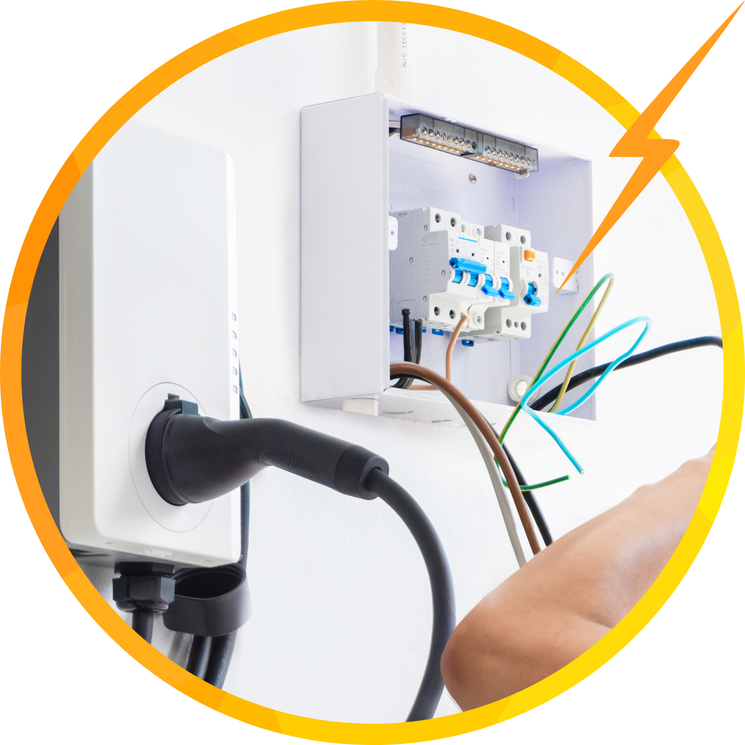 Electric car charger connected to a breaker box; wiring visible with a hand reaching towards it.