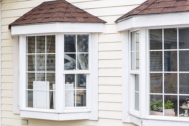 A house with two bay windows and a brown roof