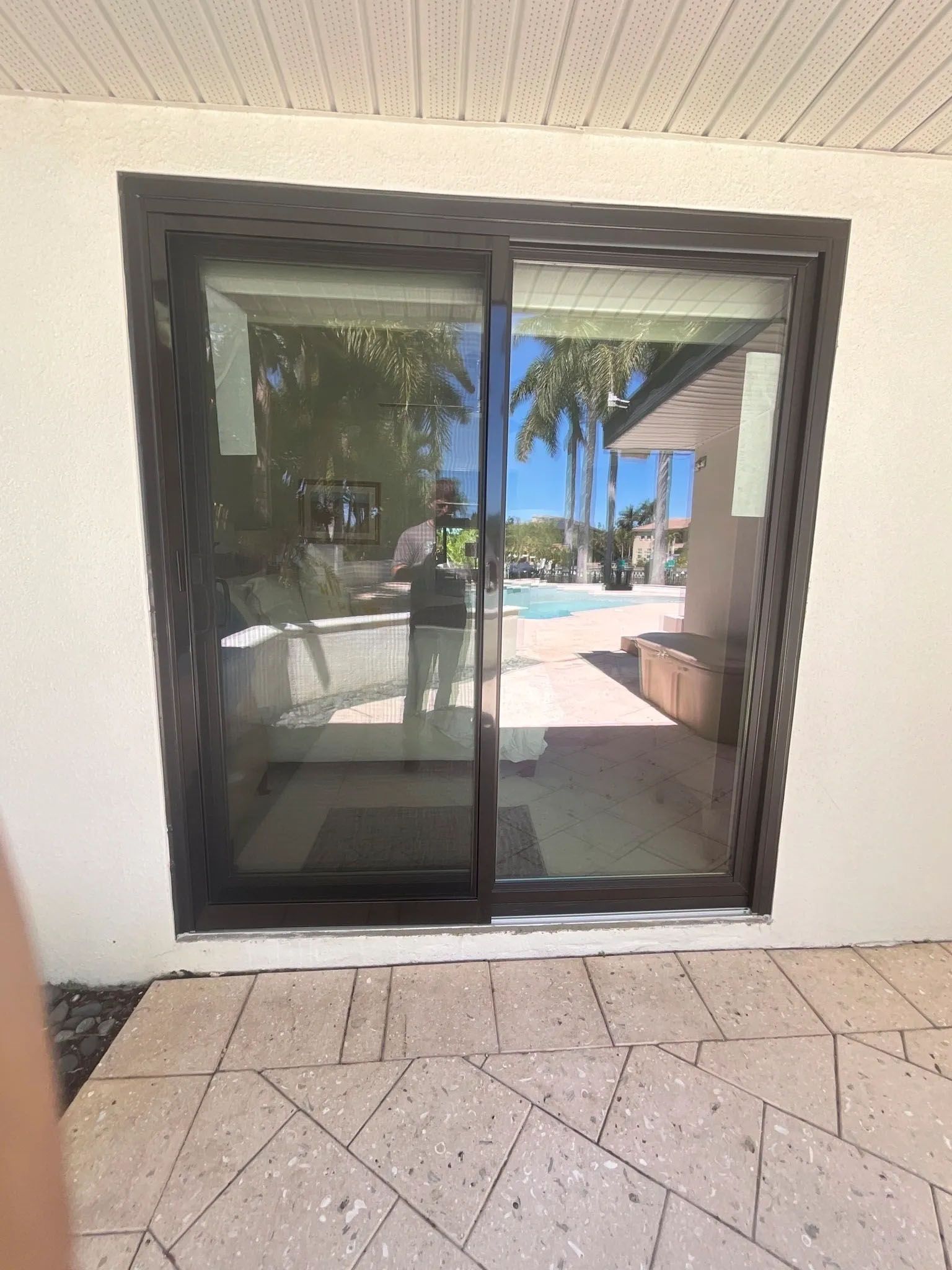 A man is standing in front of a sliding glass door.